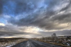 黄昏下的雪地乌云下的雪地公路高清图片