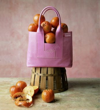 粉色手提包中的橘子背景