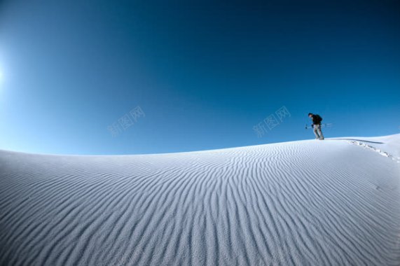 蓝天下行走在雪山的人背景