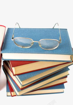 蓝色凌乱放着眼镜的堆起来的书实素材