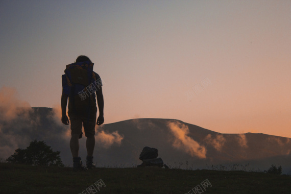 行走的背包客山顶背景摄影图片