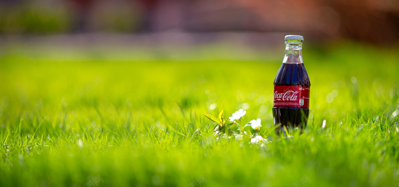 可口可乐饮料绿色草地背景摄影图片