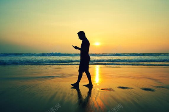 黄昏下走在沙滩的男人背景