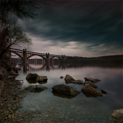 乌云桥湖水礁石黑暗背景下的大桥高清图片