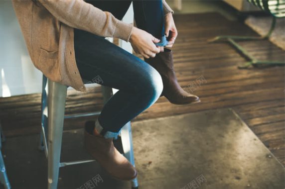 坐在凳子上挽裤脚的女子背景