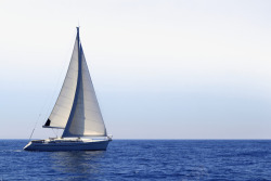 海面上轮渡一辆航行在蓝色大海上的帆船高清图片