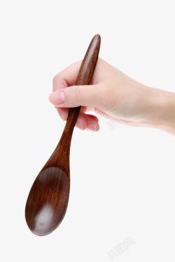 手拿着棕色的木汤勺实物素材