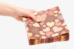 手拿着一叠棕色布满心形的餐巾纸素材